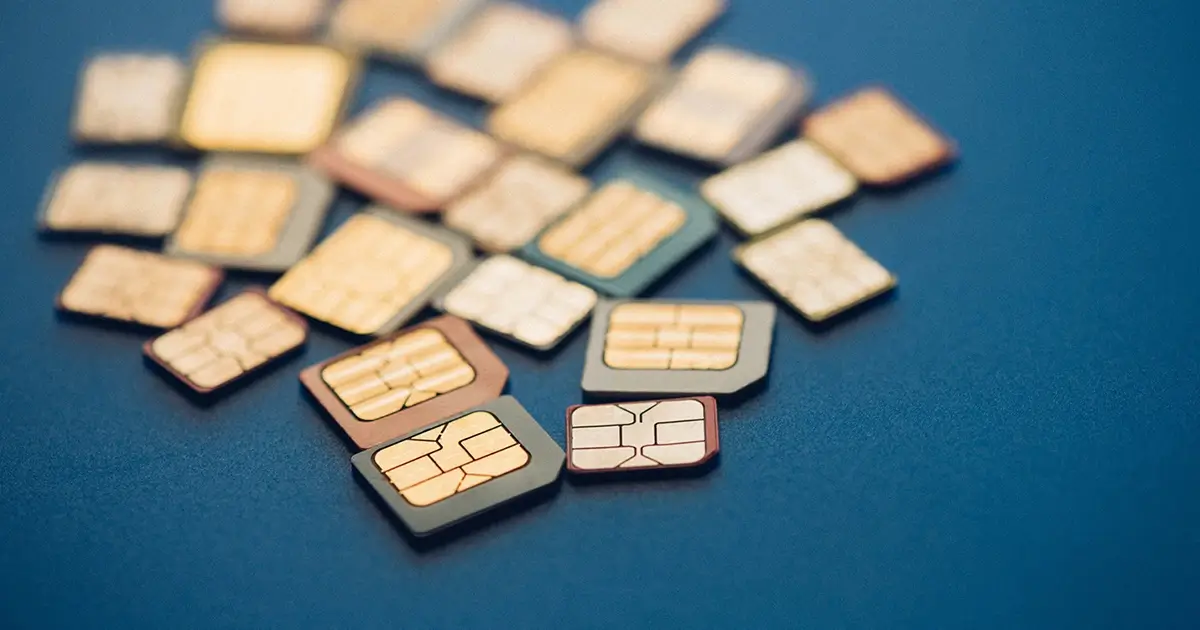 Multiple SIM cards clustered on a blue surface